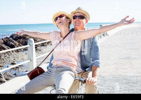 Casual couple heureux de faire une promenade en vélo sur la jetée Banque D'Images