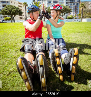 Monter couple du roller sur l'herbe Banque D'Images