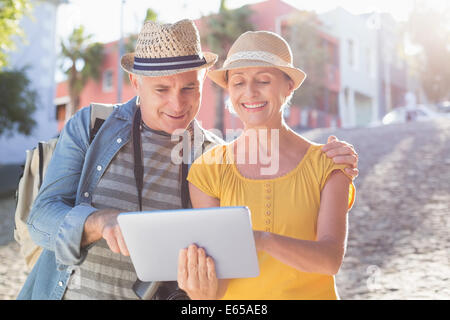 Happy tourist couple using tablet pc dans la ville Banque D'Images