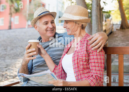 Happy tourist couple boire du café sur un banc dans la ville Banque D'Images