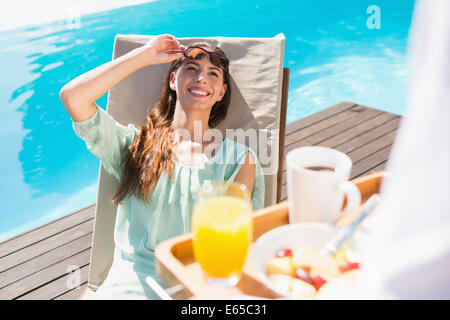 Smiling woman looking at waiter avec plateau de petit-déjeuner Banque D'Images