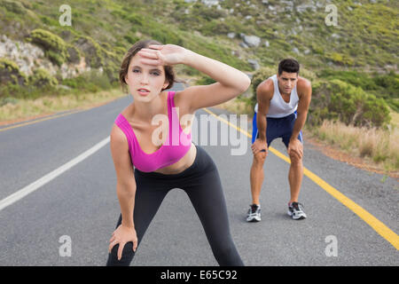 Fit young couple running on road Banque D'Images