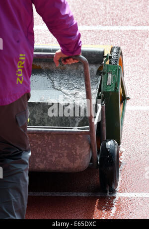 Zurich, Suisse. 15e Août, 2014. Un bénévole tente de sécher la piste, à l'athlétisme 2014 au stade du Letzigrund à Zurich, Suisse, 15 août 2014. Photo : Rainer Jensen/dpa/Alamy Live News Banque D'Images