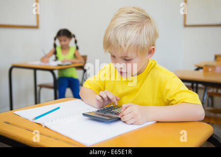 Cute pupils working in classroom Banque D'Images