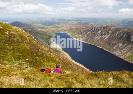 Une femelle Walker et son chien à la recherche à l'Cowlyd Carneddau réservoir dans la gamme de montagne du Parc National de Snowdonia, le Pays de Galles Banque D'Images