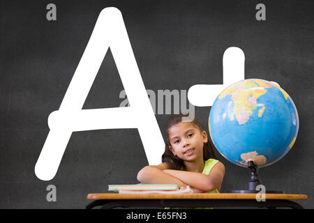 Image composite de cute pupils sitting at desk Banque D'Images
