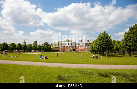 Visiteurs ou touristes se détendre au soleil sur une journée d'été à l'extérieur de Dunham Massey Hall Altrincham Greater Manchester Cheshire Banque D'Images