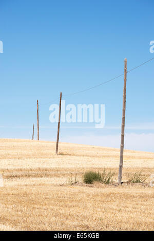 Les poteaux de téléphone diminuer dans un paysage sec de l'Espagne rurale Banque D'Images