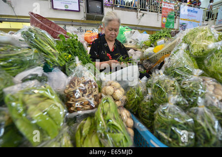 Chiang Mai, Thaïlande - 14 Février 2014 : une femme vendant des légumes au marché Warorot dans Chiang Mai, Thaïlande. Banque D'Images