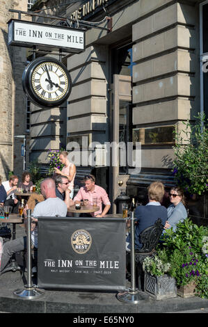 Les gens de prendre un verre à l'extérieur de l'hôtel The Inn on the Mile un soir d'été sur le Royal Mile, Édimbourg Banque D'Images