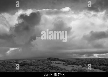 Un noir et blanc paysage de nuages s'accumuler sur la lande hills. Banque D'Images