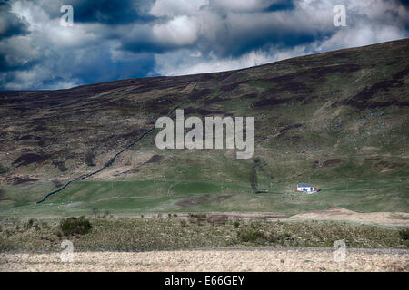 Assis au pied de Craig et Hulich le long de la façon dont Rob Roy, est ce petit chalet blanc. Highland Perthshire, en Écosse. Banque D'Images