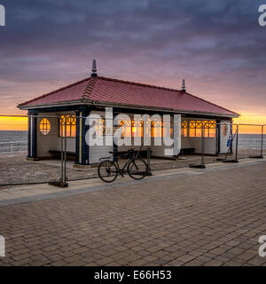 Aberystwyth, Pays de Galles, Royaume-Uni. 20 juillet 2014. Coucher de soleil derrière l'abri de la PROM PRESQUE TERMINÉ. Six mois après les tempêtes dévastatrices presque détruit la promenade, le dernier des réparations au front de Aberystwyth terminé cette semaine. La clôture est venu révéler une prom, refuge rénové méconnaissable de l'endommagé une cet hiver. © Keith Morris/Alamy dispose d' Banque D'Images