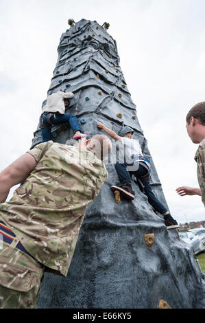 High Street, Worcester, Royaume-Uni. 16 août 2014. Première Guerre mondiale et a donné le salut des armes modernes à l'Hippodrome de Worcester comme l'un des points forts de la journée spéciale de l'artillerie, qui marque le 150e anniversaire de la ville de l'unité de la réserve de l'armée locale, 214 (Worcestershire) de la batterie de l'Artillerie royale. Sur la photo : escaladais à enfants une colonne d'escalade installé sur hippodrome de Worcester dans le cadre de la Journée de l'Artillerie de la ville. Credit : Lee Thomas/Alamy Live News Banque D'Images