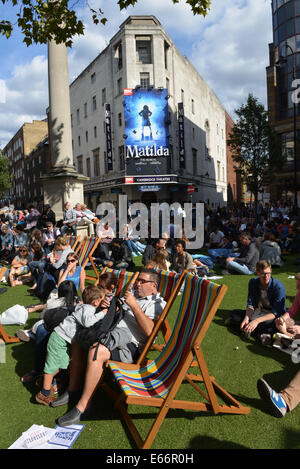 Seven Dials, Londres, Royaume-Uni. 16 août 2014. Les gens se reposer sur des chaises longues au soleil. Les sept cadrans est libre du trafic et le couvercle dans le gazon artificiel que les gens apprécient le festival. Crédit : Matthieu Chattle/Alamy Live News Banque D'Images