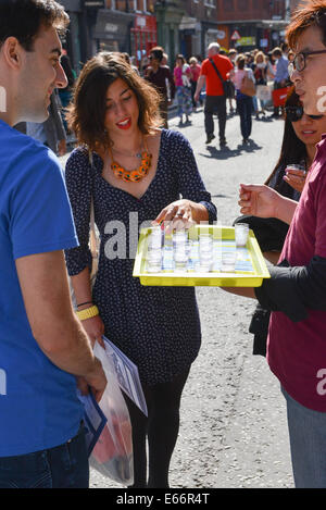 Seven Dials, Londres, Royaume-Uni. 16 août 2014. Les gens prendre boissons et nourriture à la festival gratuit. Les sept cadrans est libre du trafic et le couvercle dans le gazon artificiel que les gens apprécient le festival. Crédit : Matthieu Chattle/Alamy Live News Banque D'Images