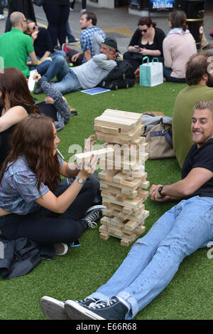 Seven Dials, Londres, Royaume-Uni. 16 août 2014. Les gens jouent à des jeux sur l'herbe' dans 'Seven Dials. Les sept cadrans est libre du trafic et le couvercle dans le gazon artificiel que les gens apprécient le festival. Crédit : Matthieu Chattle/Alamy Live News Banque D'Images