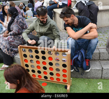 Seven Dials, Londres, Royaume-Uni. 16 août 2014. Les gens jouent à des jeux sur l'herbe' dans 'Seven Dials. Les sept cadrans est libre du trafic et le couvercle dans le gazon artificiel que les gens apprécient le festival. Crédit : Matthieu Chattle/Alamy Live News Banque D'Images