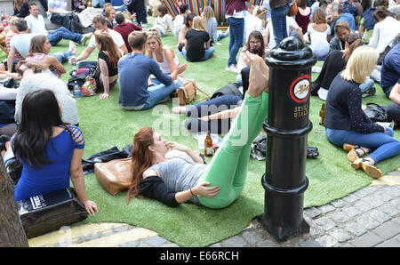 Seven Dials, Londres, Royaume-Uni. 16 août 2014. Une femme prend un repos au soleil. Les sept cadrans est libre du trafic et le couvercle dans le gazon artificiel que les gens apprécient le festival. Crédit : Matthieu Chattle/Alamy Live News Banque D'Images