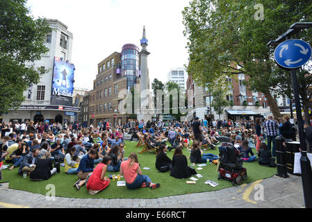 Seven Dials, Londres, Royaume-Uni. 16 août 2014. Les sept cadrans est libre du trafic et le couvercle dans le gazon artificiel que les gens apprécient le festival. Crédit : Matthieu Chattle/Alamy Live News Banque D'Images