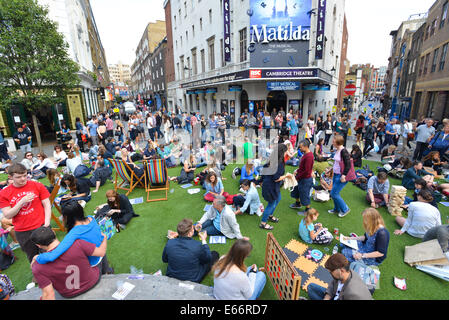 Seven Dials, Londres, Royaume-Uni. 16 août 2014. Les sept cadrans est libre du trafic et le couvercle dans le gazon artificiel que les gens apprécient le festival. Crédit : Matthieu Chattle/Alamy Live News Banque D'Images