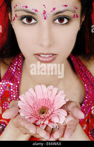 Indian woman holding a pink flower Banque D'Images