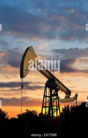 L'extraction du pétrole par pumpjack dans région du Caucase, au coucher du soleil d'été Banque D'Images