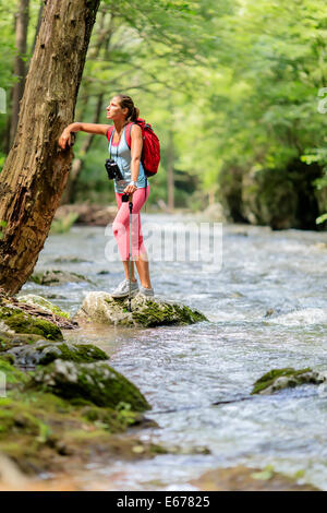 Jeune femme en randonnée dans la forêt Banque D'Images