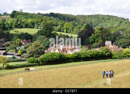 Argent - Chiltern Hills - Turville - meadow cottage premier plan - walkers - toits - tour de l'église - les collines boisées au-delà - sun Banque D'Images