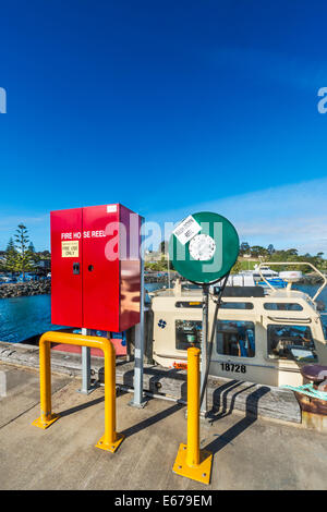 D'INCENDIE rouge aux couleurs vives et vert flexible de rallonge sur le quai, Port Eden Eden, NSW Australie Banque D'Images