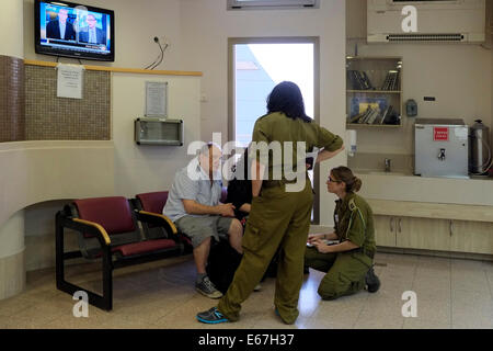 Soldats israéliens de l'unité de commandement du front intérieur, responsables de la défense civile et de l'assistance à la population pendant le conflit et la crise, parlant aux parents d'un soldat blessé au centre médical de Soroka, situé dans la ville de Beersheba, dans le sud d'Israël Banque D'Images