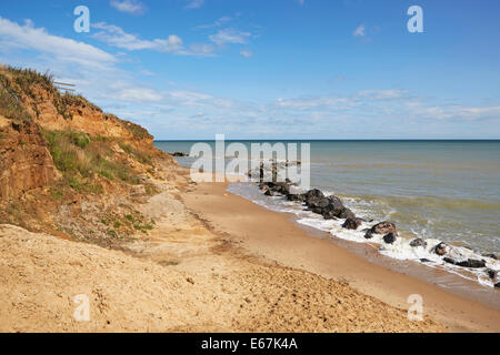 Happisburgh beach North Norfolk montrant l'effondrement des falaises et rochers placés pour retarder l'érosion côtière Banque D'Images