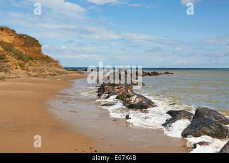 Happisburgh beach North Norfolk montrant l'effondrement des falaises et rochers placés pour retarder l'érosion côtière Banque D'Images