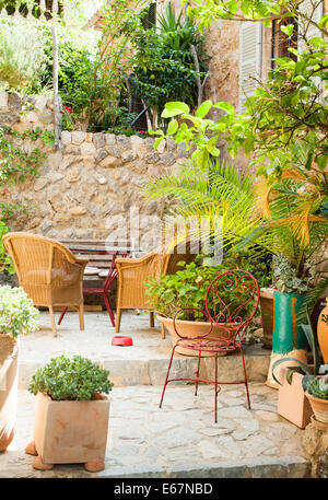 Cour traditionnelle avec des chaises et un lot o Fleurs dans vieux village dans l'île de Majorque, Espagne Banque D'Images