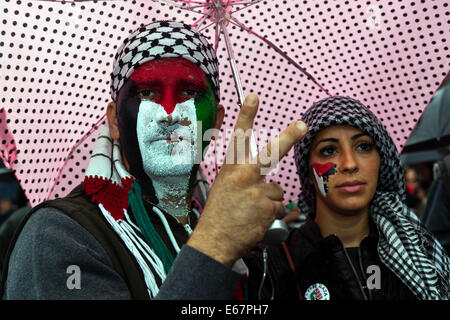 Copenhague, Danemark. 17 août, 2014. Malgré une pluie de centaines de se rassembler dans un Futurama correspondent à la paix à l'appui d'enfants de Gaza et contre la guerre israélienne dans leur pays. La marche pour la paix a pris fin devant le parlement danois, Christiansborg, après une longue promenade de 2 heures à travers la ville. Sur la photo d'un couple, où l'homme est en train de faire le signe de la victoire. Credit : OJPHOTOS/Alamy Live News Banque D'Images