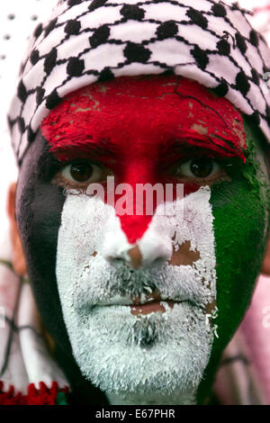 Copenhague, Danemark. 17 août, 2014. Malgré une pluie de centaines de se rassembler dans un Futurama correspondent à la paix à l'appui d'enfants de Gaza et contre la guerre israélienne dans leur pays. La marche pour la paix a pris fin devant le parlement danois, Christiansborg, après une longue promenade de 2 heures à travers la ville. Sur la photo un homme a peint son visage aux couleurs de l'Palestinain drapeau. Credit : OJPHOTOS/Alamy Live News Banque D'Images