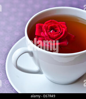 Tasse de thé et une rose rouge Banque D'Images