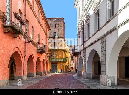 Rue étroite pavée entre les anciens bâtiments médiévaux et renouvelé dans la ville de Alba dans le Piémont, Italie du Nord. Banque D'Images