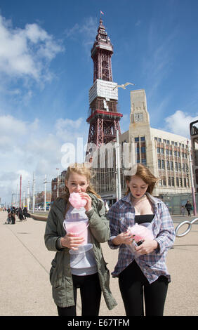 Eating Candy Floss in Blackpool Lancashire UK en arrière-plan la célèbre Tour de Blackpool Banque D'Images