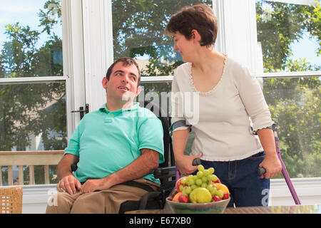 Couple avec la paralysie cérébrale assis sur leur deck Banque D'Images