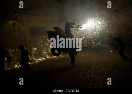Barcelone, Espagne. 17 août, 2014. Dragon en carton dans les rues de Barcelone le feu de respiration. Correfocs, une vieille tradition catalane où les gens habillés en démons faire exploser des pétards et des fusées éclairantes, prendre part aux célébrations pour le Festival Sant Roc dans le quartier gothique de Barcelone. Crédit : Jordi Boixareu/Alamy Live News Banque D'Images