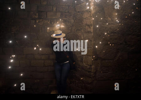 Barcelone, Espagne. 17 août, 2014. Un téléspectateur protéger les charbons et prendre des photos pendant un festival pyrotechnique dans les rues de Barcelone. Correfocs, une vieille tradition catalane où les gens habillés en démons faire exploser des pétards et des fusées éclairantes, prendre part aux célébrations pour le Festival Sant Roc dans le quartier gothique de Barcelone. Crédit : Jordi Boixareu/Alamy Live News Banque D'Images