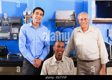 Instructeur et deux étudiants en matière de génie climatique et de contrôle de processus de classe un élève en fauteuil roulant Banque D'Images