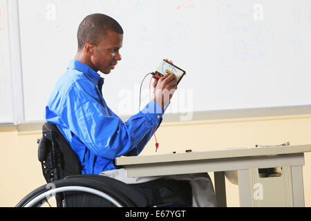 Étudiant en génie civil de fauteuil roulant de la méningite dans le placement des composants breadboard prototypage Banque D'Images