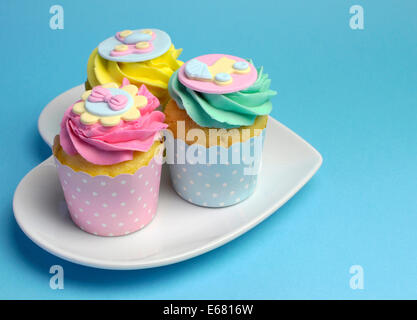 Belle Rose, aqua bleu et jaune sur les cupcakes en forme de coeur blanc, plaque de douche de bébé ou parti pour enfants. Banque D'Images