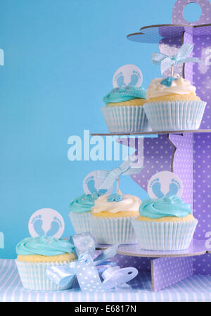 Bébé garçon thème bleu à pois violet sur cupcakes cupcake stand against blue background Banque D'Images