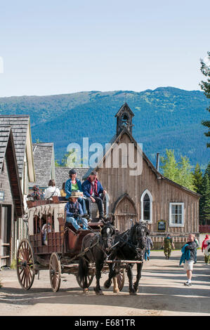 Personnes équitation une diligence dans la ville d'or historique de Barkerville, British Columbia, Canada. Banque D'Images