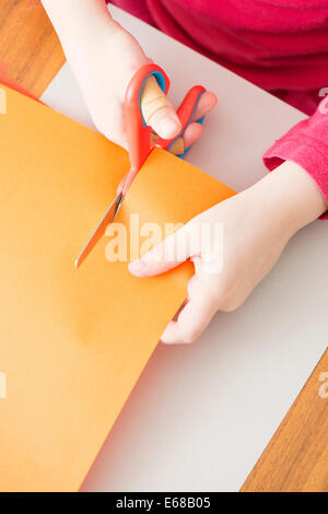 Petite fille de papier avec des ciseaux de coupe Banque D'Images