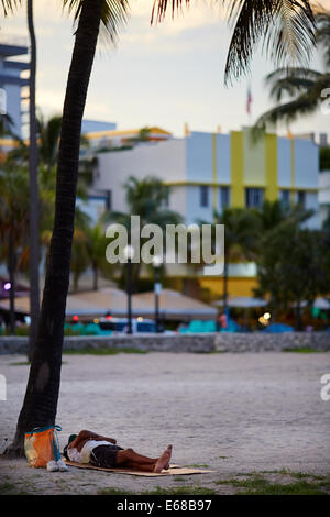 Miami en Floride USA un homme dormir sur la plage autour d'Ocean Drive. Banque D'Images