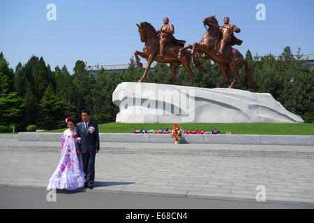 Mariée et le marié en face de statue de grands leaders Kim Il Sung et Kim Jong Il, Pyongyang, Corée du Nord Banque D'Images